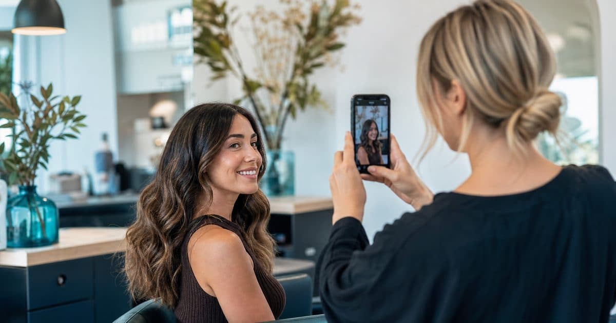 Salon owner photographing a client for social media content in the salon